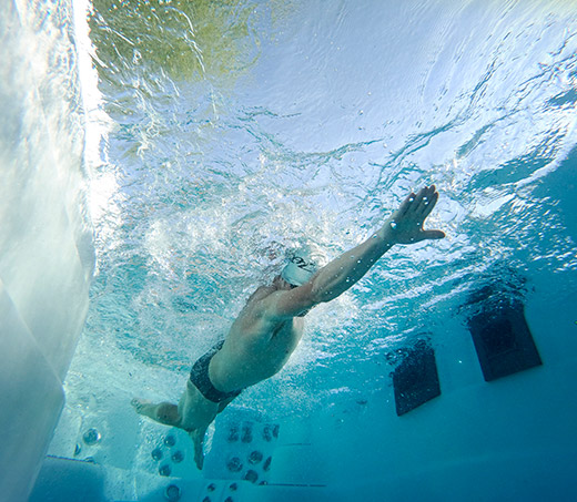 Ben Hoffman nage sous l'eau dans un spa de natation h2x fitness.