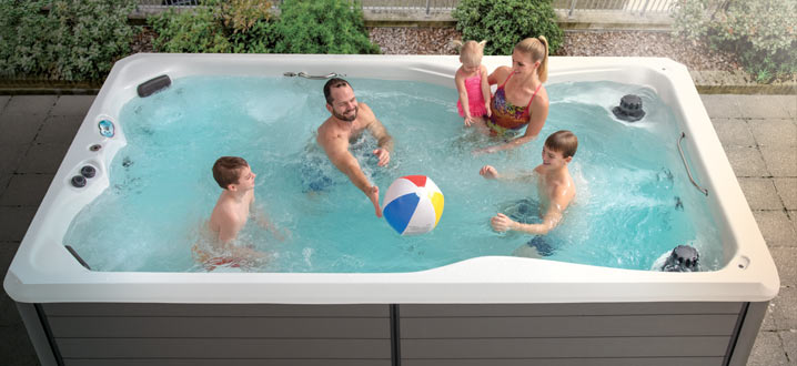Famille jouant avec un ballon de plage dans un spa de natation