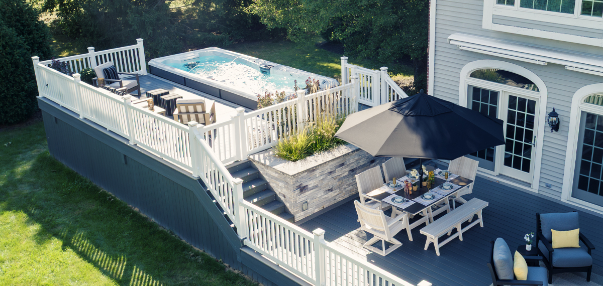 Un spa de nage entouré d'une terrasse.
