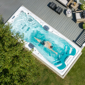 Vue prise par un drone d'un nageur dans un Swim Spa H2X Fitness.