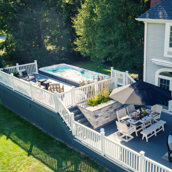 Un spa de nage entouré d'une terrasse.