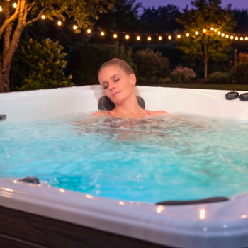 Une femme se détend dans un spa de nage équipé de jets de massage.