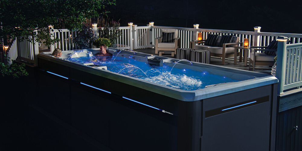 Un spa de nage la nuit, avec toutes les LED allumées et les jeux d'eau en marche.