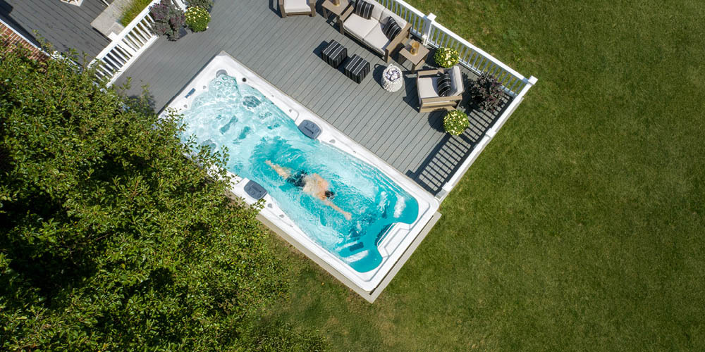 Vue prise par un drone d'une personne nageant à contre-courant dans un spa de nage.