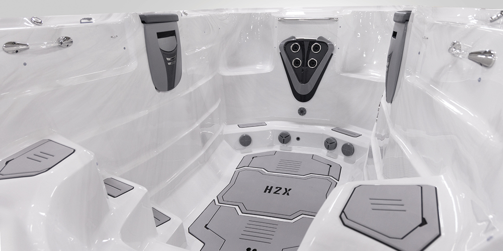 Vue de l'intérieur d'un spa de nage H2X Fitness sans eau, mettant l'accent sur les jets.