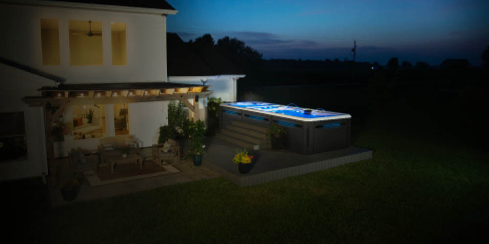 Photo prise de nuit d'un spa de nage dans un jardin.